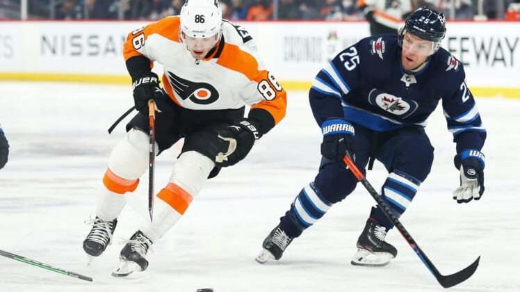 Apr 27, 2022; Winnipeg, Manitoba, CAN; Philadelphia Flyers forward Noah Farabee (86) tries to skate around Winnipeg Jets forward Paul Stasny (25) during the first period at Canada Life Centre. Mandatory Credit: Terrence Lee-USA TODAY Sports