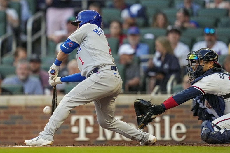 Apr 27, 2022; Cumberland, Georgia, USA; Chicago Cubs second baseman Nick Madrigal (1) hits into a fielders choice to score a run against the Atlanta Braves during the second inning at Truist Park. Mandatory Credit: Dale Zanine-USA TODAY Sports