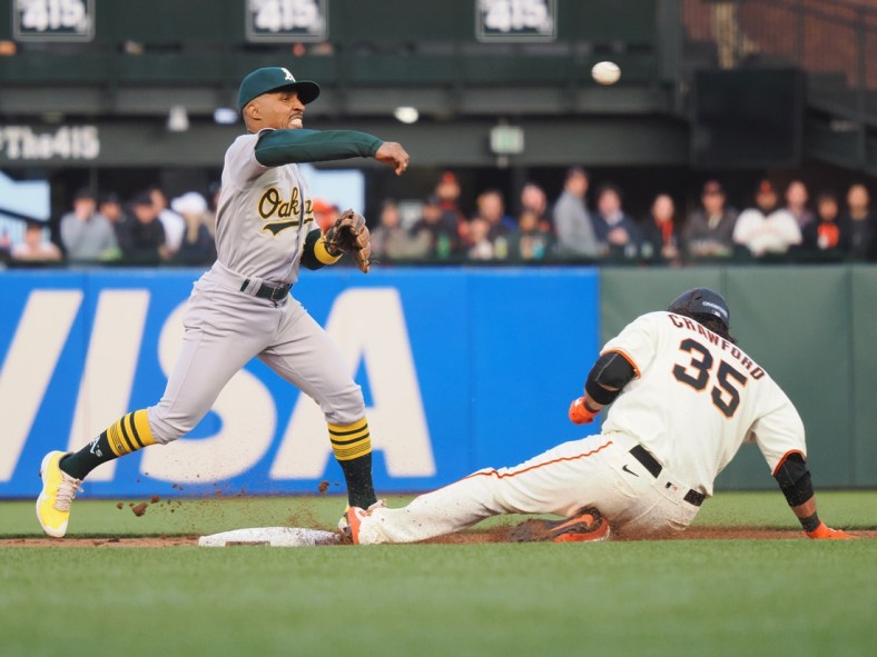 Apr 27, 2022; San Francisco, California, USA; Oakland Athletics second baseman Tony Kemp (5) turns a double play against San Francisco Giants shortstop Brandon Crawford (35) during the second inning at Oracle Park. Mandatory Credit: Kelley L Cox-USA TODAY Sports