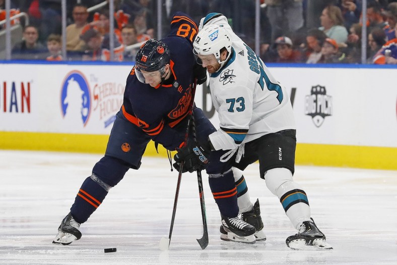 Apr 28, 2022; Edmonton, Alberta, CAN; Edmonton Oilers forward Zach Hyman (18) and San Jose Sharks forward Noah Gregor (73) battle for a loose puck during the first period at Rogers Place. Mandatory Credit: Perry Nelson-USA TODAY Sports