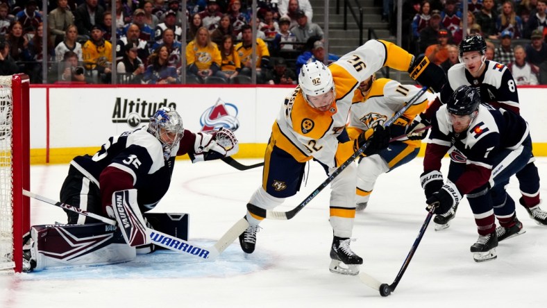 Apr 28, 2022; Denver, Colorado, USA; Colorado Avalanche defenseman Devon Toews (7) pokes the puck away from Nashville Predators center Ryan Johansen (92) and goaltender Darcy Kuemper (35) defends the net in the first period at Ball Arena. Mandatory Credit: Ron Chenoy-USA TODAY Sports