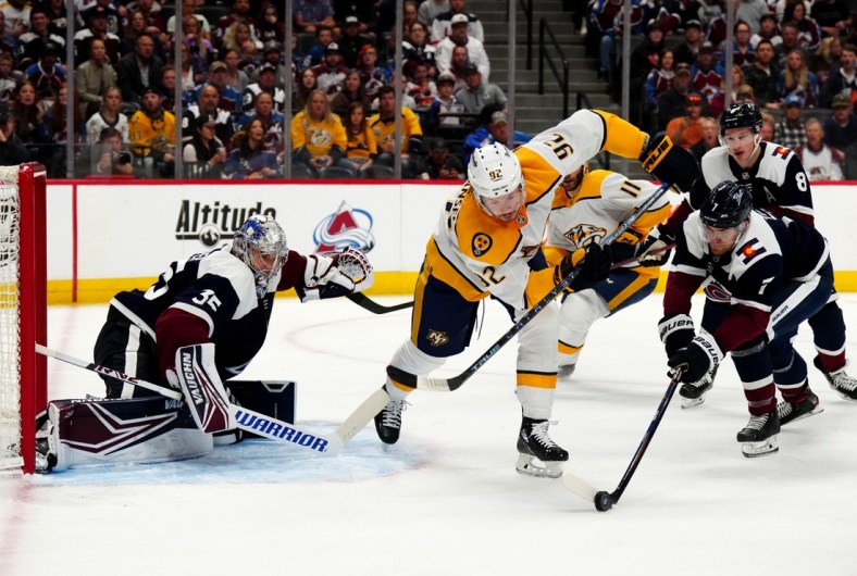 Apr 28, 2022; Denver, Colorado, USA; Colorado Avalanche defenseman Devon Toews (7) pokes the puck away from Nashville Predators center Ryan Johansen (92) and goaltender Darcy Kuemper (35) defends the net in the first period at Ball Arena. Mandatory Credit: Ron Chenoy-USA TODAY Sports