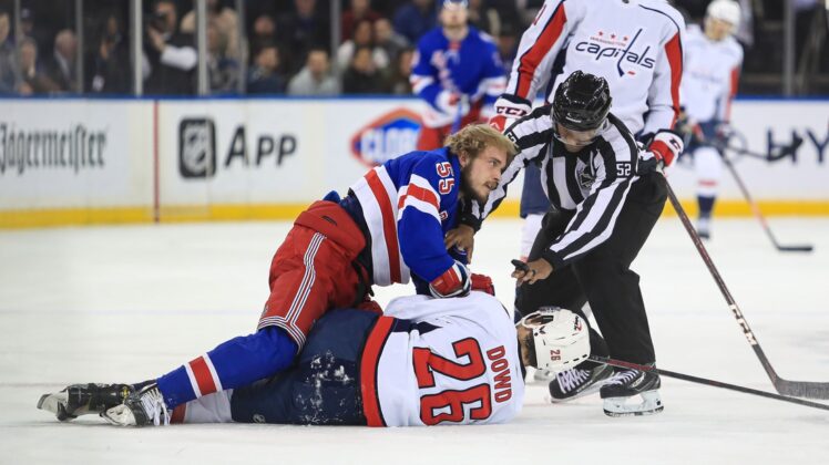 Apr 29, 2022; New York, New York, USA; New York Rangers defenseman Ryan Lindgren (55) and Washington Capitals center Nic Dowd (26) battle on the ice during the first period at Madison Square Garden. Mandatory Credit: Danny Wild-USA TODAY Sports