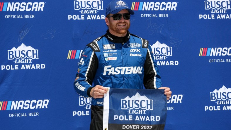 Apr 30, 2022; Dover, Delaware, USA; NASCAR Cup Series driver Chris Buescher stands with the Busch Light Pole Award after winning the pole during qualifying for the DuraMAX Drydene 400 at Dover Motor Speedway. Mandatory Credit: Matthew OHaren-USA TODAY Sports