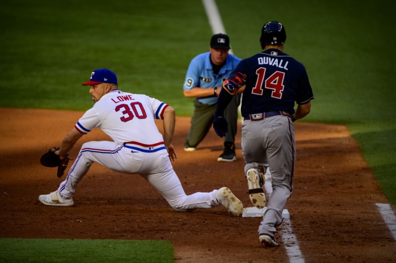 Apr 30, 2022; Arlington, Texas, USA; Texas Rangers first baseman Nathaniel Lowe (30) puts out Atlanta Braves center fielder Adam Duvall (14) during the fifth inning at Globe Life Field. Mandatory Credit: Jerome Miron-USA TODAY Sports