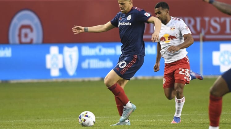 Apr 30, 2022; Chicago, Illinois, USA;  Chicago Fire midfielder Gast  n Gim  nez (30) moves the ball against New York Red Bulls midfielder Cristian C  sseres Jr (23) during the first half at Soldier Field. Mandatory Credit: Matt Marton-USA TODAY Sports