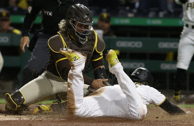 Apr 30, 2022; Pittsburgh, Pennsylvania, USA;  Pittsburgh Pirates third baseman Ke'Bryan Hayes (right) slides into home against San Diego Padres catcher Jorge Alfaro (left) during the tenth inning at PNC Park. Hayes was originally ruled out on the play and the Pirates won the appeal. Pittsburgh won 7-6 in ten innings. Mandatory Credit: Charles LeClaire-USA TODAY Sports