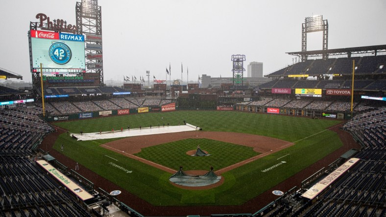 Aug 29, 2020; Philadelphia, Pennsylvania, USA; The grounds crew cover the field during a rain delay in seventh inning of a game between the Philadelphia Phillies and the Atlanta Braves at Citizens Bank Park. Mandatory Credit: Bill Streicher-USA TODAY Sports