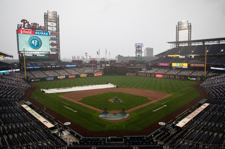 Aug 29, 2020; Philadelphia, Pennsylvania, USA; The grounds crew cover the field during a rain delay in seventh inning of a game between the Philadelphia Phillies and the Atlanta Braves at Citizens Bank Park. Mandatory Credit: Bill Streicher-USA TODAY Sports