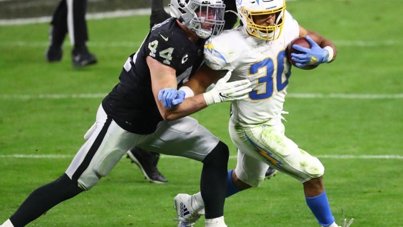 Dec 17, 2020; Paradise, Nevada, USA; Los Angeles Chargers running back Austin Ekeler (30) runs the ball against Las Vegas Raiders inside linebacker Nick Kwiatkoski (44) during the second half at Allegiant Stadium. Mandatory Credit: Mark J. Rebilas-USA TODAY Sports