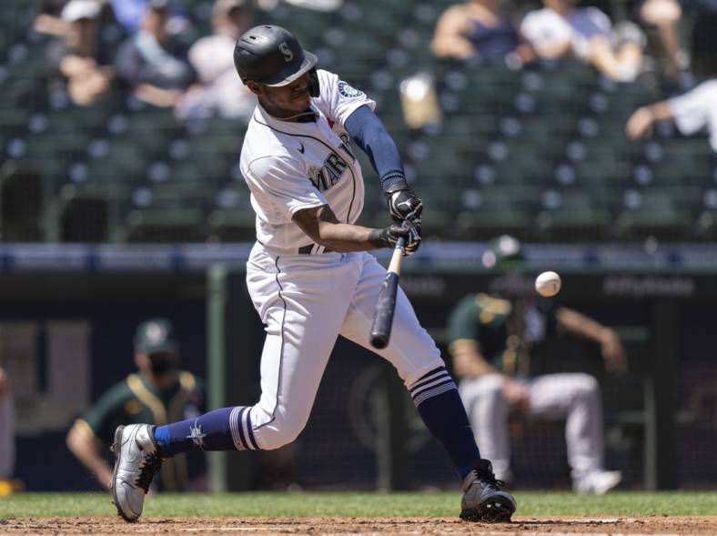 May 31, 2021; Seattle, Washington, USA; Seattle Mariners centerfielder Kyle Lewis (1) hits an RBI-double off of Oakland Athletics starting pitcher James Kaprielian (32) during the fourth inning of a game at T-Mobile Park. Mandatory Credit: Stephen Brashear-USA TODAY Sports