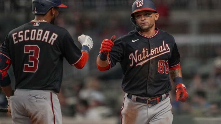 Aug 6, 2021; Cumberland, Georgia, USA; Washington Nationals right fielder Gerardo Parra (88) fist bumps with shortstop Alcides Escobar (3) after scoring a run against the Atlanta Braves during the fifth inning at Truist Park. Mandatory Credit: Dale Zanine-USA TODAY Sports