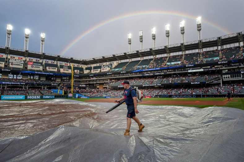 Aug 7, 2021; Cleveland, Ohio, USA; A member of the Cleveland Indians grounds crew cleans the tarp after a rain delay before the game between the Cleveland Indians and the Detroit Tigers at Progressive Field. Mandatory Credit: Ken Blaze-USA TODAY Sports