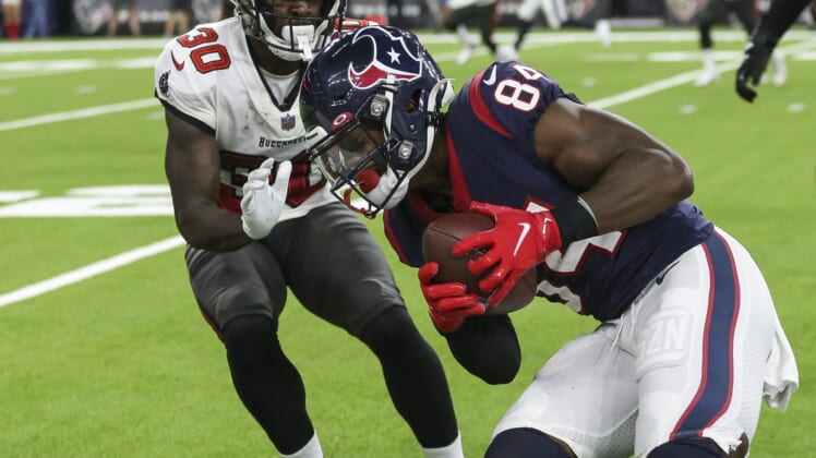 Aug 28, 2021; Houston, Texas, USA; Houston Texans wide receiver Jordan Veasy (84) runs with the ball after a reception as Tampa Bay Buccaneers defensive back Dee Delaney (30) attempts to make a tackle during the fourth quarter at NRG Stadium. Mandatory Credit: Troy Taormina-USA TODAY Sports