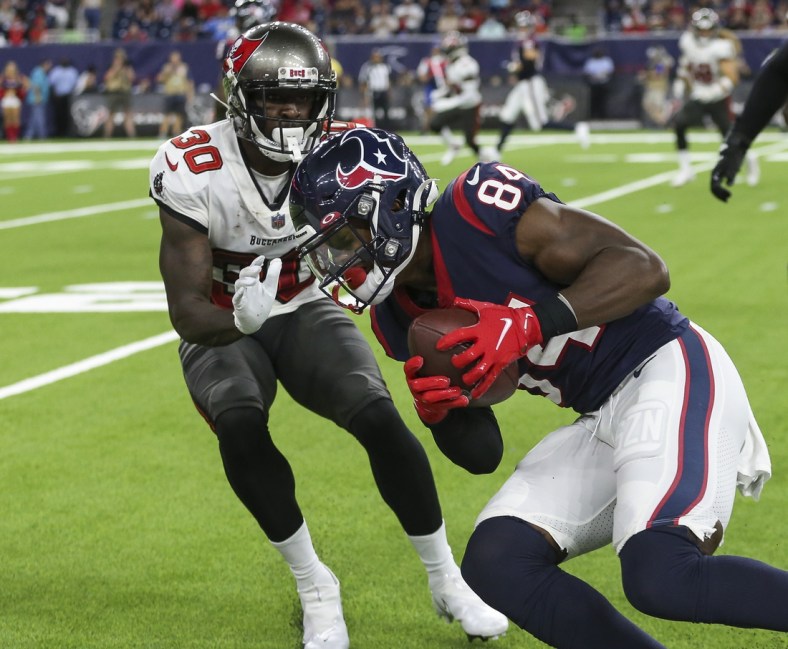 Aug 28, 2021; Houston, Texas, USA; Houston Texans wide receiver Jordan Veasy (84) runs with the ball after a reception as Tampa Bay Buccaneers defensive back Dee Delaney (30) attempts to make a tackle during the fourth quarter at NRG Stadium. Mandatory Credit: Troy Taormina-USA TODAY Sports