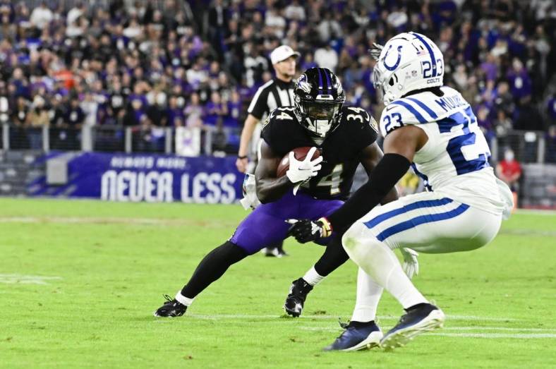 Oct 11, 2021; Baltimore, Maryland, USA;  Baltimore Ravens running back Ty'Son Williams (34) rushes by Indianapolis Colts cornerback Kenny Moore II (23) during the second half  at M&T Bank Stadium. Mandatory Credit: Tommy Gilligan-USA TODAY Sports