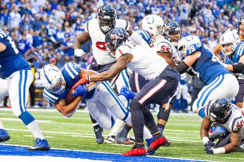Oct 17, 2021; Indianapolis, Indiana, USA; Indianapolis Colts running back Jonathan Taylor (28) scores a touchdown while Houston Texans safety Lonnie Johnson (1) defends  in the second half at Lucas Oil Stadium. Mandatory Credit: Trevor Ruszkowski-USA TODAY Sports
