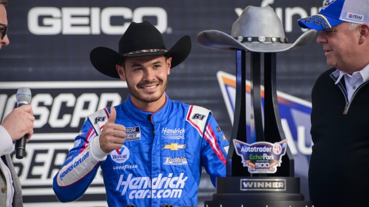 Oct 17, 2021; Fort Worth, Texas, USA; NASCAR Cup Series driver Kyle Larson (5) poses with the trophy in victory lane after he wins the Autotrader EchoPark Automotive 500 in the NASCAR round of 8 opening race at Texas Motor Speedway. Mandatory Credit: Jerome Miron-USA TODAY Sports