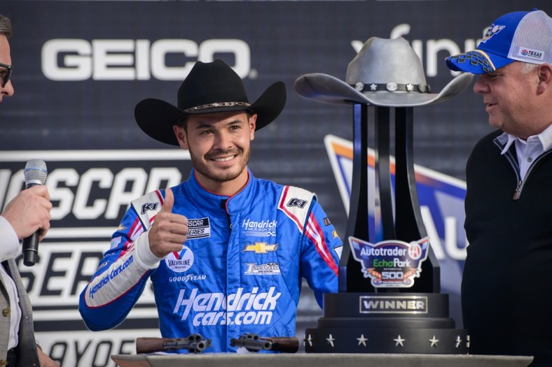 Oct 17, 2021; Fort Worth, Texas, USA; NASCAR Cup Series driver Kyle Larson (5) poses with the trophy in victory lane after he wins the Autotrader EchoPark Automotive 500 in the NASCAR round of 8 opening race at Texas Motor Speedway. Mandatory Credit: Jerome Miron-USA TODAY Sports