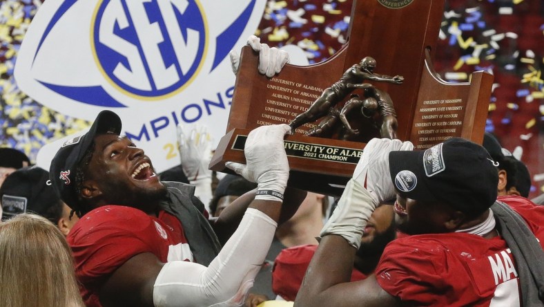 Dec 4, 2021; Atlanta, GA, USA; Alabama Crimson Tide linebacker Will Anderson Jr. (31) and defensive lineman Phidarian Mathis (48) hoist the trophy after defeating the Georgia Bulldogs in the SEC championship game at Mercedes-Benz Stadium. Alabama won 41-24. Mandatory Credit: Gary Cosby Jr.-USA TODAY Sports