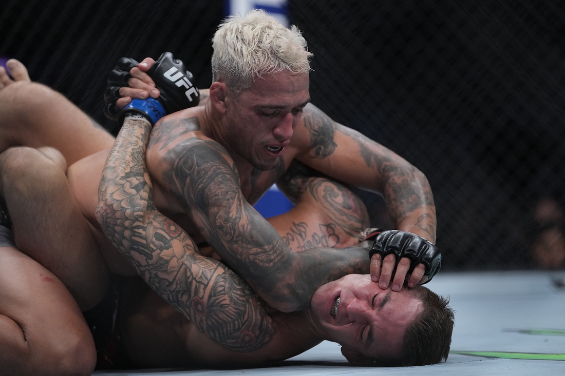 Dec 11, 2021; Las Vegas, Nevada, USA; Charles Oliveira pins Dustin Poirier to the mat during UFC 269 at T-Mobile Arena. Mandatory Credit: Stephen R. Sylvanie-USA TODAY Sports