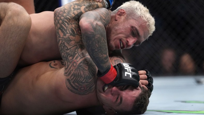 Dec 11, 2021; Las Vegas, Nevada, USA; Charles Oliveira pins Dustin Poirier to the mat during UFC 269 at T-Mobile Arena. Mandatory Credit: Stephen R. Sylvanie-USA TODAY Sports