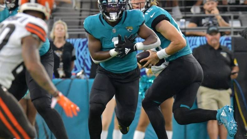 Jacksonville Jaguars running back Travis Etienne (1) fakes taking a handoff from Jacksonville Jaguars quarterback Trevor Lawrence (16) during first quarter action. The Jacksonville Jaguars hosted the Cleveland Browns for their only home preseason game at TIAA Bank Field in Jacksonville, Florida Saturday night, August 14, 2021. The Browns led at the half 13 to 0.  [Bob Self/Florida Times-Union]

Jki 081421 Jagsvsbrowns 52