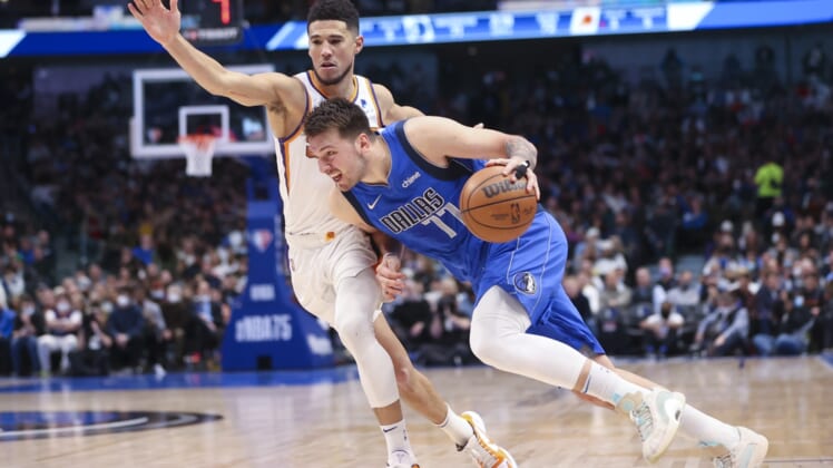 Jan 20, 2022; Dallas, Texas, USA;  Dallas Mavericks guard Luka Doncic (77) drives to the basket as Phoenix Suns guard Devin Booker (1) defends during the second half at American Airlines Center. Mandatory Credit: Kevin Jairaj-USA TODAY Sports