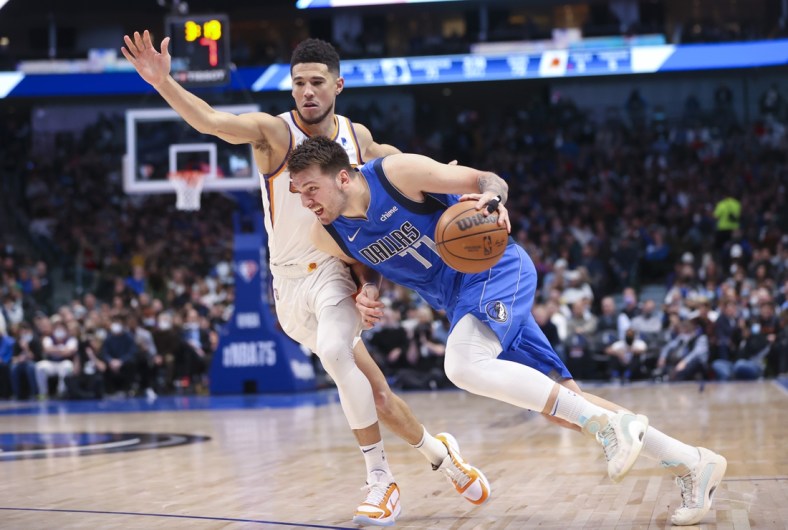 Jan 20, 2022; Dallas, Texas, USA;  Dallas Mavericks guard Luka Doncic (77) drives to the basket as Phoenix Suns guard Devin Booker (1) defends during the second half at American Airlines Center. Mandatory Credit: Kevin Jairaj-USA TODAY Sports
