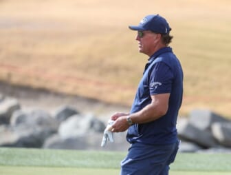 Phil Mickelson gives advice to an amateur in his group while playing the 11th green of the Pete Dye Stadium course during the third round of The American Express at PGA West in La Quinta, Calif., Saturday, Jan. 22, 2022.