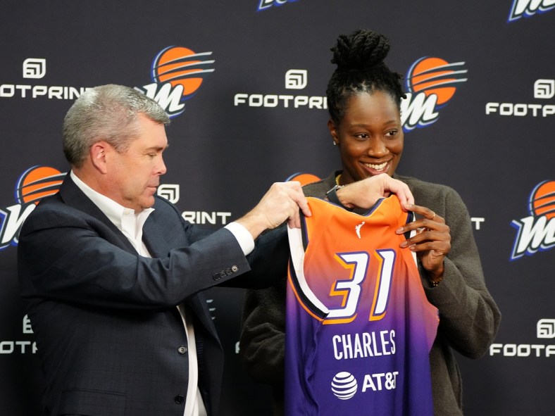 Feb 10, 2022; Phoenix, Arizona, USA; Phoenix Mercury general manager Jim Pitman (left) and Tina Charles hold up her jersey during Charles    introductory press conference at Footprint Center. Mandatory Credit: Patrick Breen-The Republic