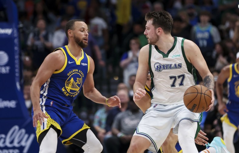 Mar 3, 2022; Dallas, Texas, USA;  Dallas Mavericks guard Luka Doncic (77) dribbles as Golden State Warriors guard Stephen Curry (30) defends during the game at American Airlines Center. Mandatory Credit: Kevin Jairaj-USA TODAY Sports