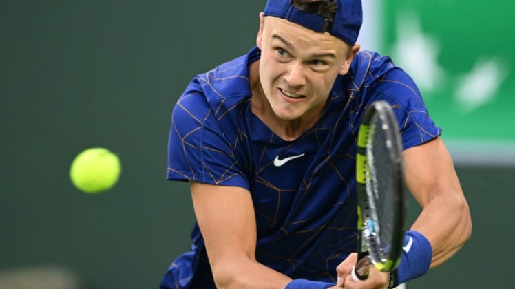 Mar 13, 2022; Indian Wells, CA, USA;  Holger Rune (DEN)  hits a shot against Matteo Berrettini (ITA) during his third round match at the BNP Paribas Open at the Indian Wells Tennis Garden. Mandatory Credit: Jayne Kamin-Oncea-USA TODAY Sports