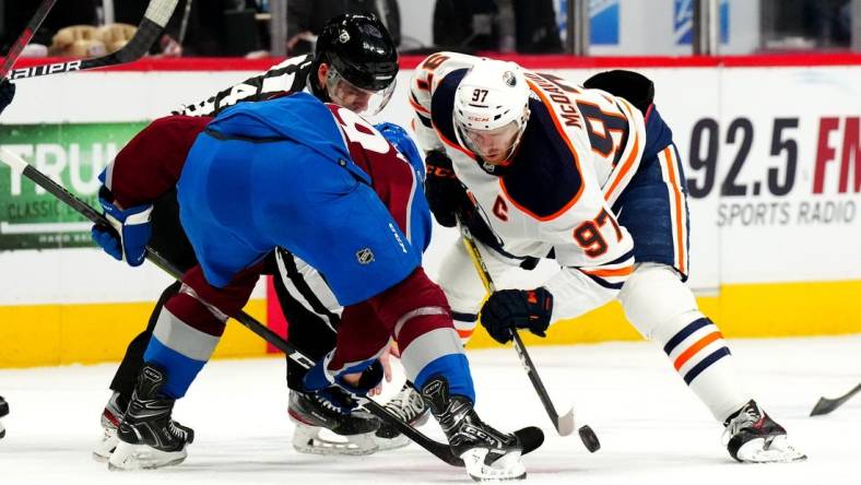 Mar 21, 2022; Denver, Colorado, USA; Colorado Avalanche center Nathan MacKinnon (29) and Edmonton Oilers center Connor McDavid (97) face off in the third period at Ball Arena. Mandatory Credit: Ron Chenoy-USA TODAY Sports