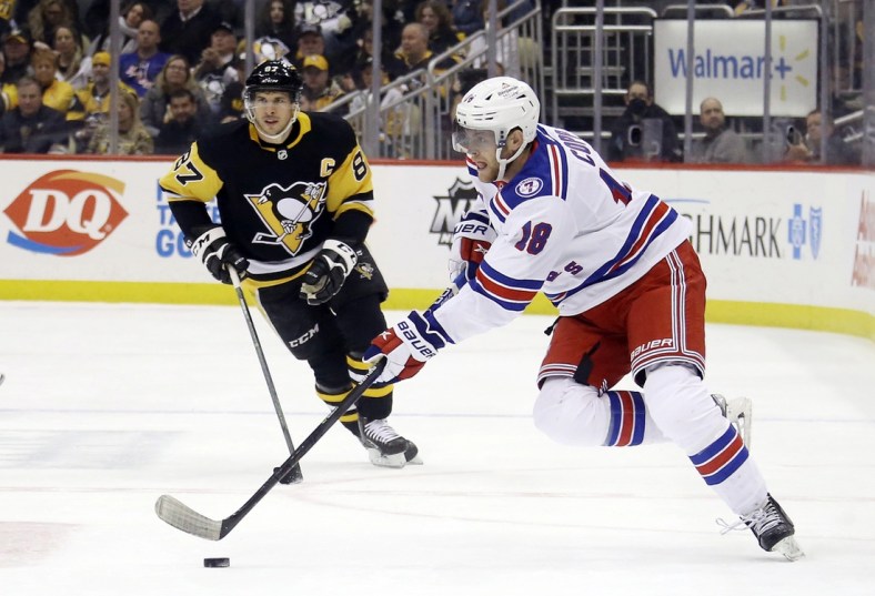 Mar 29, 2022; Pittsburgh, Pennsylvania, USA;  New York Rangers center Andrew Copp (18) skates with the puck against Pittsburgh Penguins center Sidney Crosby (87) during the first period at PPG Paints Arena. The Rangers won 3-2. Mandatory Credit: Charles LeClaire-USA TODAY Sports