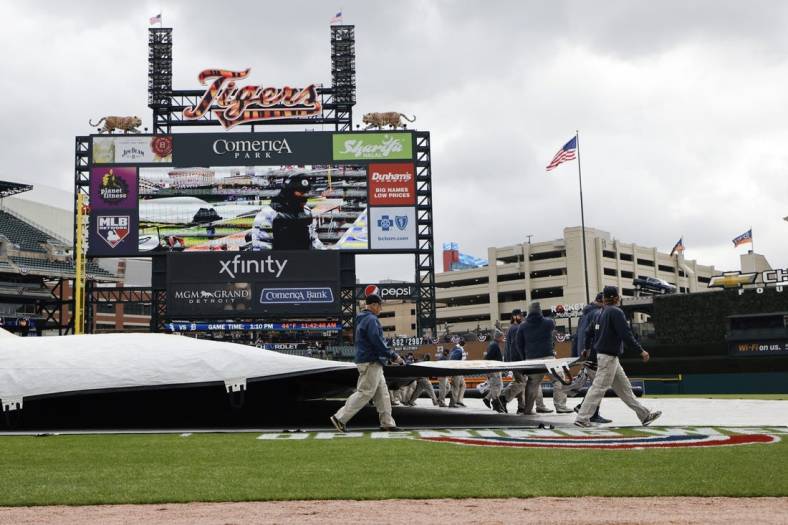 Apr 8, 2022; Detroit, Michigan, USA;  Grounds crew remove the tarp before the game between the Detroit Tigers and the Chicago White Sox at Comerica Park. Mandatory Credit: Rick Osentoski-USA TODAY Sports