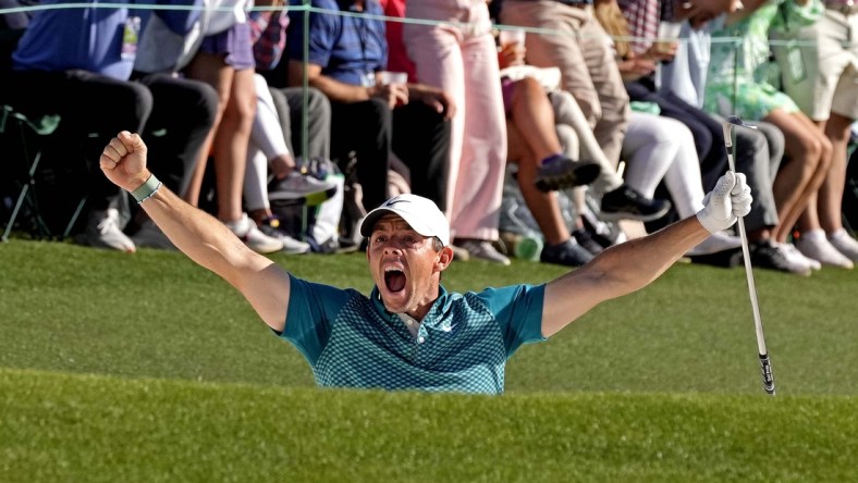 Apr 10, 2022; Augusta, Georgia, USA; Rory McIlroy celebrates after holing out from a bunker on the 18th hole during the final round of the Masters golf tournament. Mandatory Credit: Michael Madrid-USA TODAY Sports