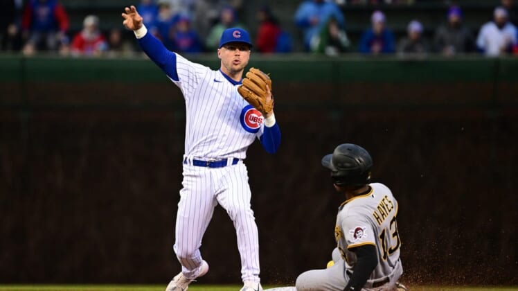 Apr 22, 2022; Chicago, Illinois, USA; Chicago Cubs shortstop Nico Hoerner (2) turns a double play in the first inning against Pittsburgh Pirates third baseman Ke'Bryan Hayes (13) at Wrigley Field. Mandatory Credit: Quinn Harris-USA TODAY Sports