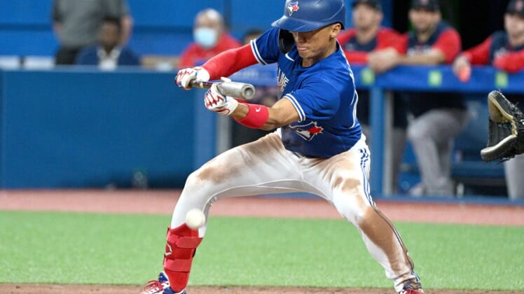 Apr 26, 2022; Toronto, Ontario, CAN; Toronto Blue Jays first baseman Gosuke Katoh (29) executes a sacrifice bunt against the Boston Red Sox in the seventh inning at Rogers Centre. Mandatory Credit: Dan Hamilton-USA TODAY Sports
