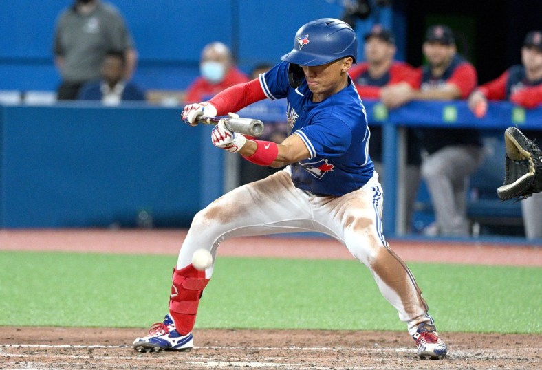 Apr 26, 2022; Toronto, Ontario, CAN; Toronto Blue Jays first baseman Gosuke Katoh (29) executes a sacrifice bunt against the Boston Red Sox in the seventh inning at Rogers Centre. Mandatory Credit: Dan Hamilton-USA TODAY Sports