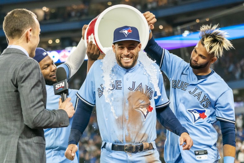 Apr 30, 2022; Toronto, Ontario, CAN; Toronto Blue Jays center fielder George Springer (4) gets ice water dumped on him by teammates first baseman Vladimir Guerrero Jr. (27) and left fielder Lourdes Gurriel Jr. (13) after defeating the Houston Astros at Rogers Centre. Mandatory Credit: Kevin Sousa-USA TODAY Sports