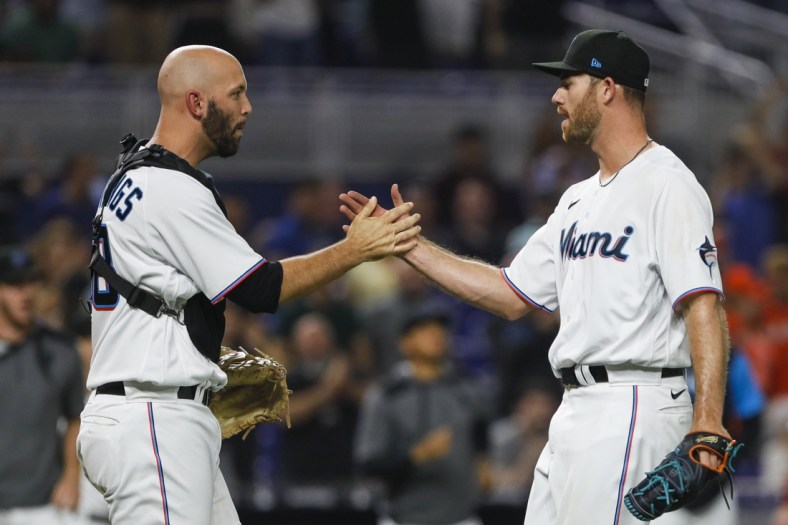 Apr 30, 2022; Miami, Florida, USA; Miami Marlins catcher Jacob Stallings (left) celebrates with relief pitcher Anthony Bender (55) after defeating the Seattle Mariners at loanDepot Park. Mandatory Credit: Sam Navarro-USA TODAY Sports