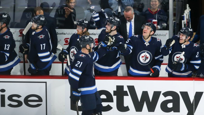 May 1, 2022; Winnipeg, Manitoba, CAN;  Winnipeg Jets forward Dominic Toninato (21) is congratulated by his team mates on his goal against Seattle Kraken goalie Chris Driedger (60) during the third period at Canada Life Centre. Mandatory Credit: Terrence Lee-USA TODAY Sports