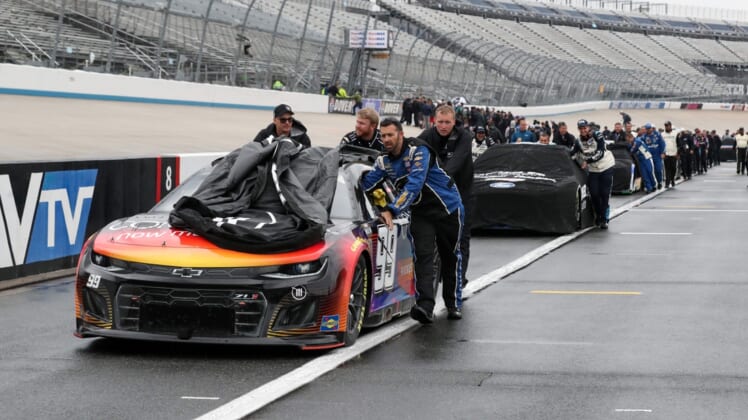 May 1, 2022; Dover, Delaware, USA; NASCAR Cup Series teams push their cars to the garage after the DuraMAX Drydene 400 has been postponed due to weather at Dover Motor Speedway. Mandatory Credit: Matthew OHaren-USA TODAY Sports