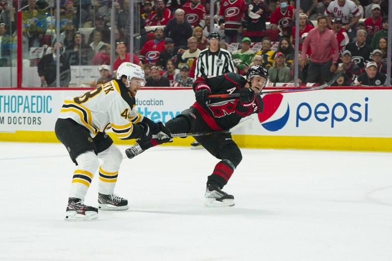 May 2, 2022; Raleigh, North Carolina, USA; Carolina Hurricanes center Sebastian Aho (20) takes a shot against Boston Bruins defenseman Matt Grzelcyk (48) during the first period in game one of the first round of the 2022 Stanley Cup Playoffs at PNC Arena. Mandatory Credit: James Guillory-USA TODAY Sports