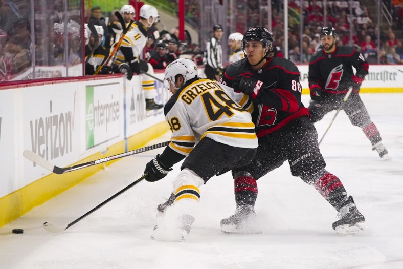 May 2, 2022; Raleigh, North Carolina, USA; Carolina Hurricanes left wing Teuvo Teravainen (86) hits Boston Bruins defenseman Matt Grzelcyk (48) during the first period in game one of the first round of the 2022 Stanley Cup Playoffs at PNC Arena. Mandatory Credit: James Guillory-USA TODAY Sports