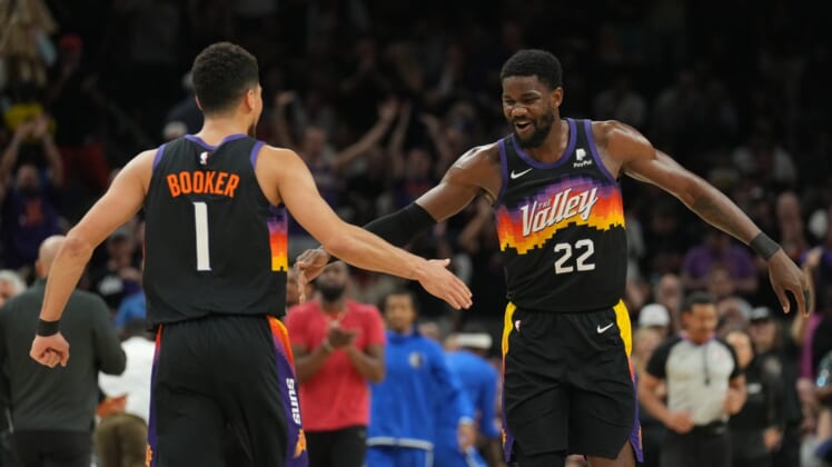 May 2, 2022; Phoenix, Arizona, USA; Phoenix Suns guard Devin Booker (1) and Phoenix Suns center Deandre Ayton (22) slap hands against the Dallas Mavericks during the first half of game one of the second round for the 2022 NBA playoffs at Footprint Center. Mandatory Credit: Joe Camporeale-USA TODAY Sports