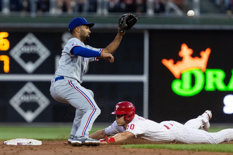 May 3, 2022; Philadelphia, Pennsylvania, USA; Philadelphia Phillies catcher J.T. Realmuto (10) advances to second base past Texas Rangers second baseman Marcus Semien (2) on a wild pitch during the third inning at Citizens Bank Park. Mandatory Credit: Bill Streicher-USA TODAY Sports