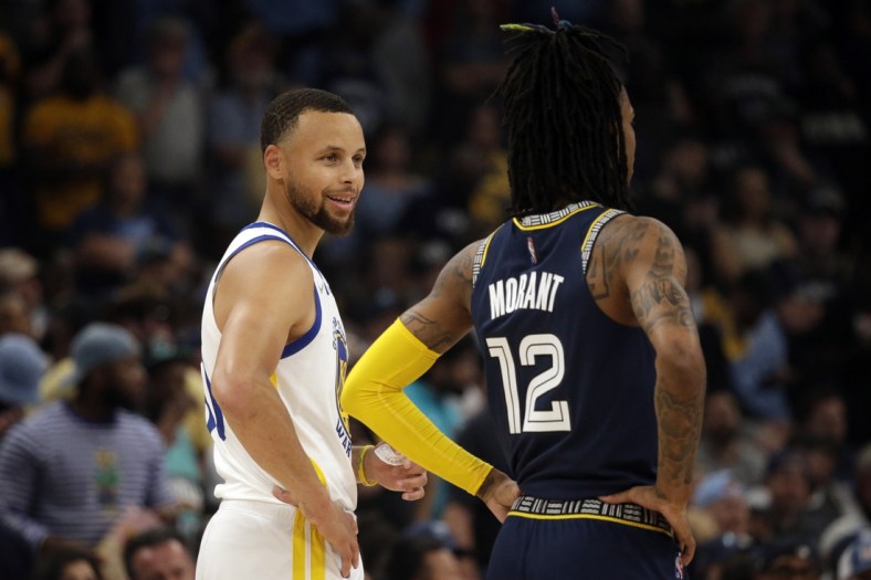May 3, 2022; Memphis, Tennessee, USA; Golden State Warriors guard Stephen Curry (left) talks with Memphis Grizzlies guard Ja Morant (12) during a timeout in game two of the second round for the 2022 NBA playoffs at FedExForum. Mandatory Credit: Petre Thomas-USA TODAY Sports