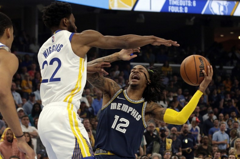 May 3, 2022; Memphis, Tennessee, USA; Memphis Grizzlies guard Ja Morant (12) drives to the basket as Golden State Warriors forward Andrew Wiggins (22) defends during the first half in game two of the second round for the 2022 NBA playoffs at FedExForum. Mandatory Credit: Petre Thomas-USA TODAY Sports